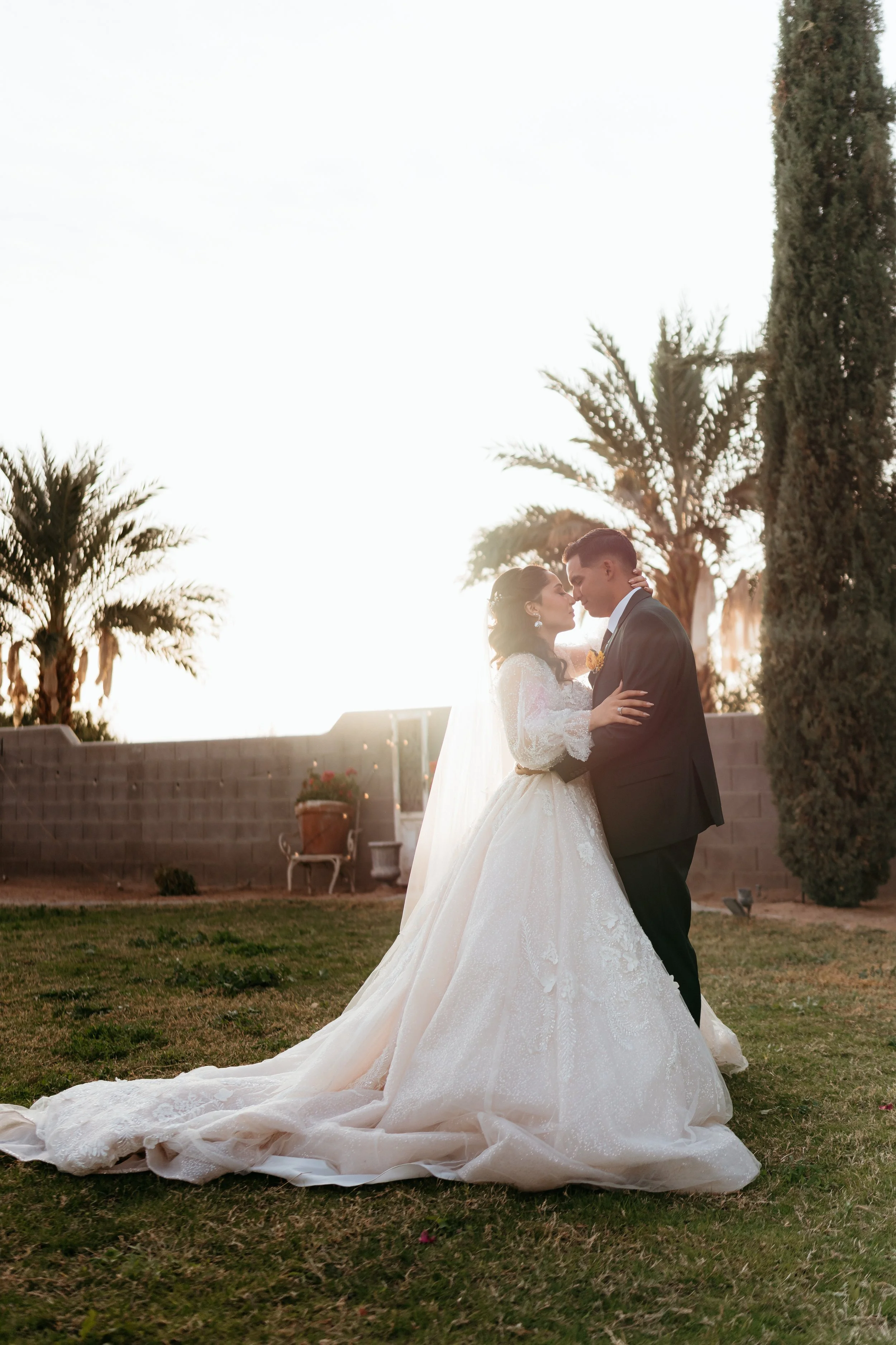 Bride and groom embracing at sunset after their ceremony.