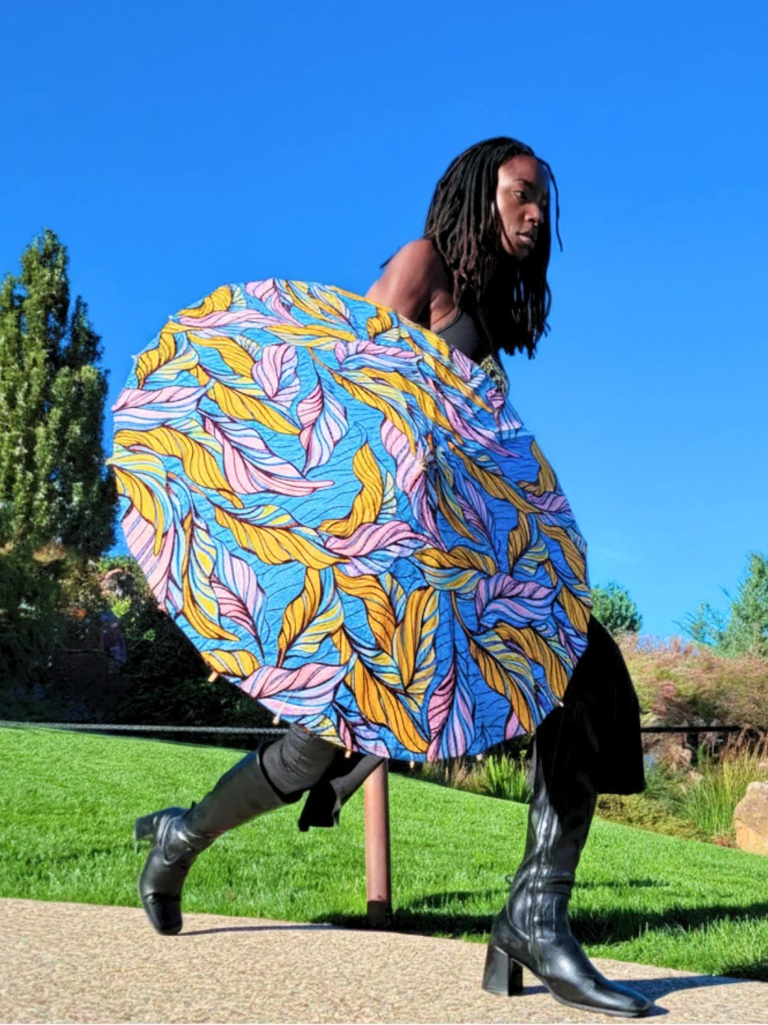 She arrives with calm already in her step, carrying a quiet harmony that does not rush the moment. 
Soft lavender, gold, and blue arc above her like a measured breath, signaling clarity held with patience and grace.

She moves forward mid-stride, the