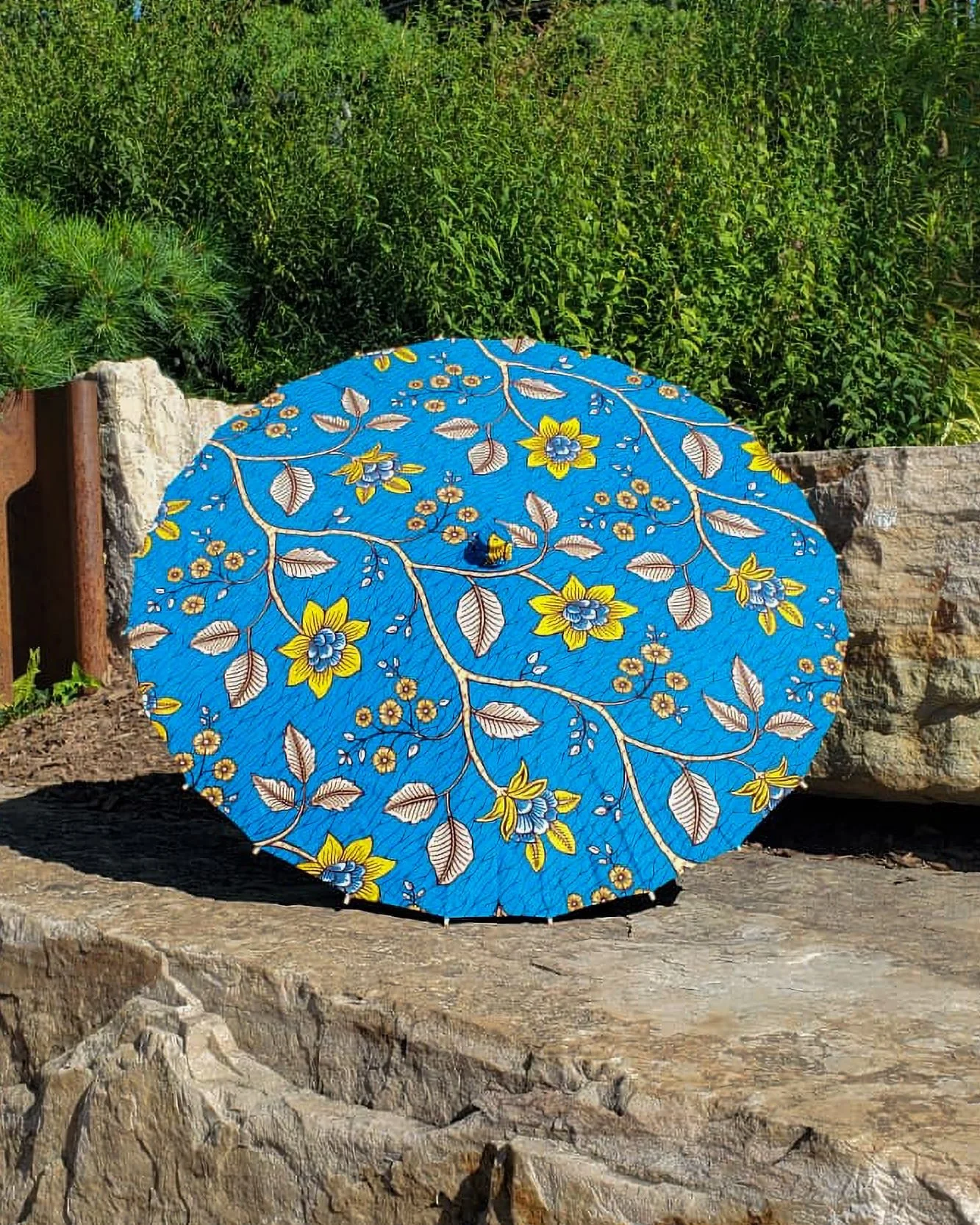 pietersite handmade parasol exterior, medium size, with afro-inspired design on a stone slab