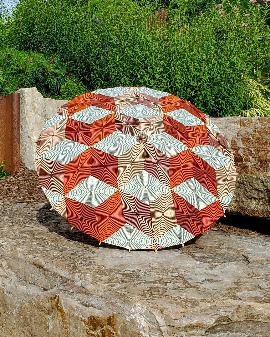 copper handmade parasol exterior, medium size, with afro-inspired design on a stone slab