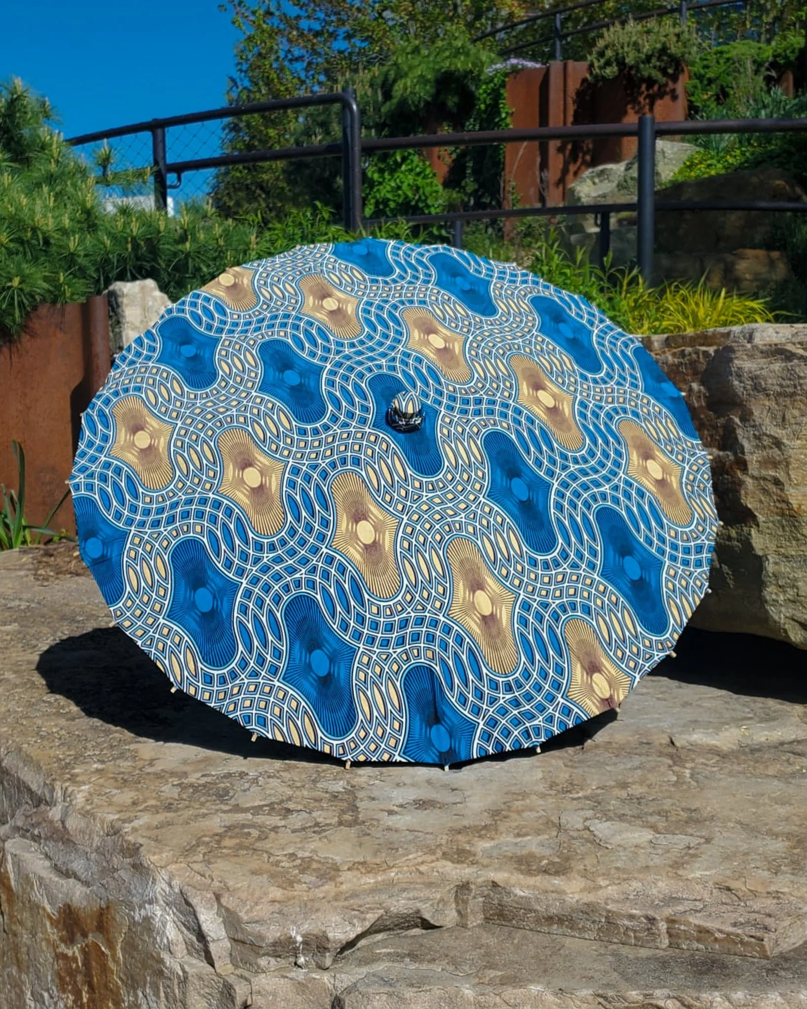 blue onyx handmade parasol exterior, medium size, with afro-inspired design on a stone slab