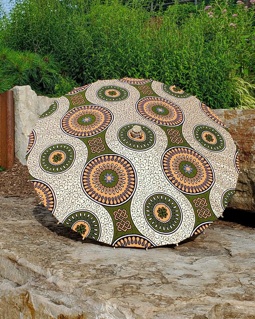 conichalcite handmade parasol exterior, medium size, with afro-inspired design on a stone slab