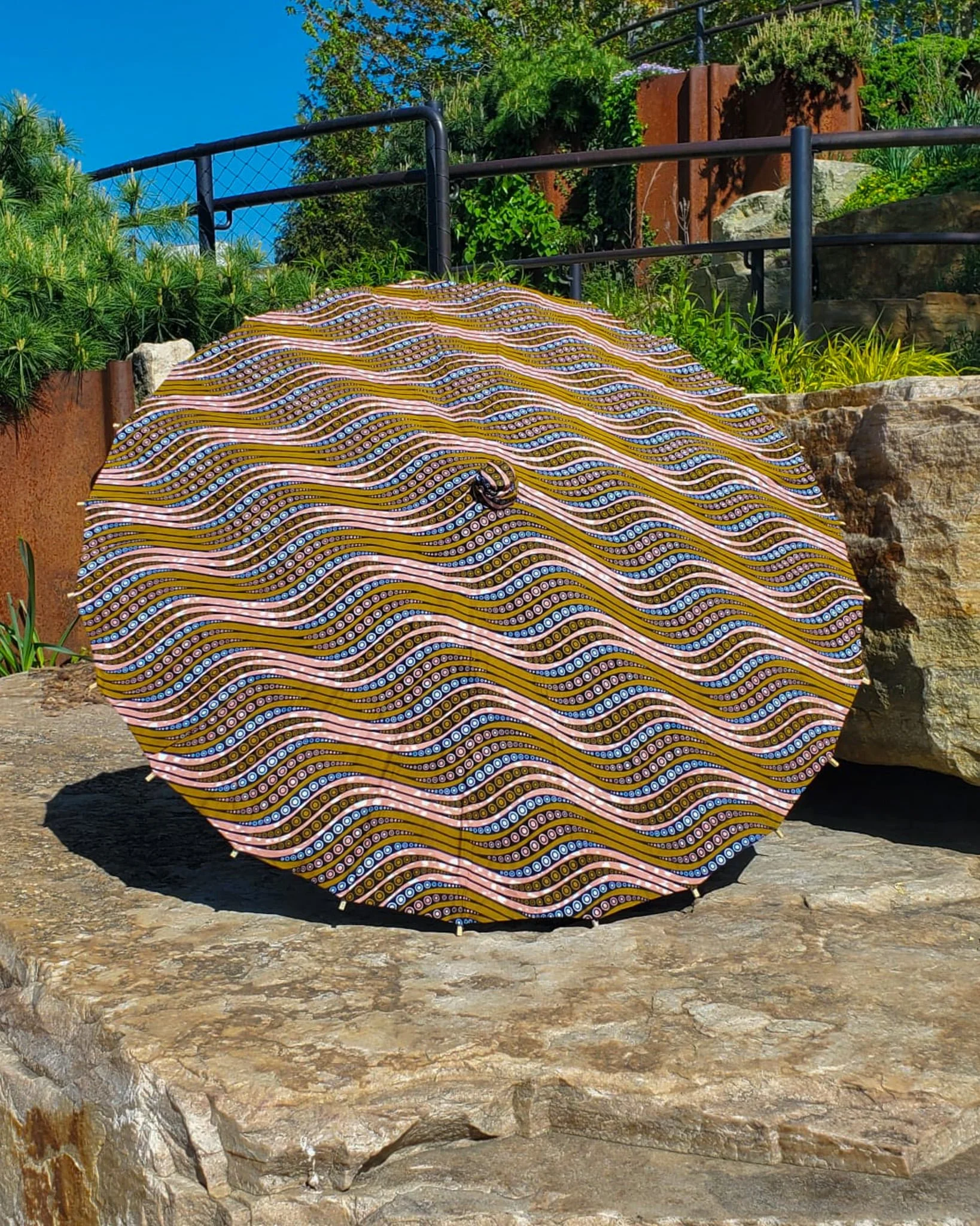 eclogite handmade parasol exterior, medium size, with afro-inspired design on a stone slab