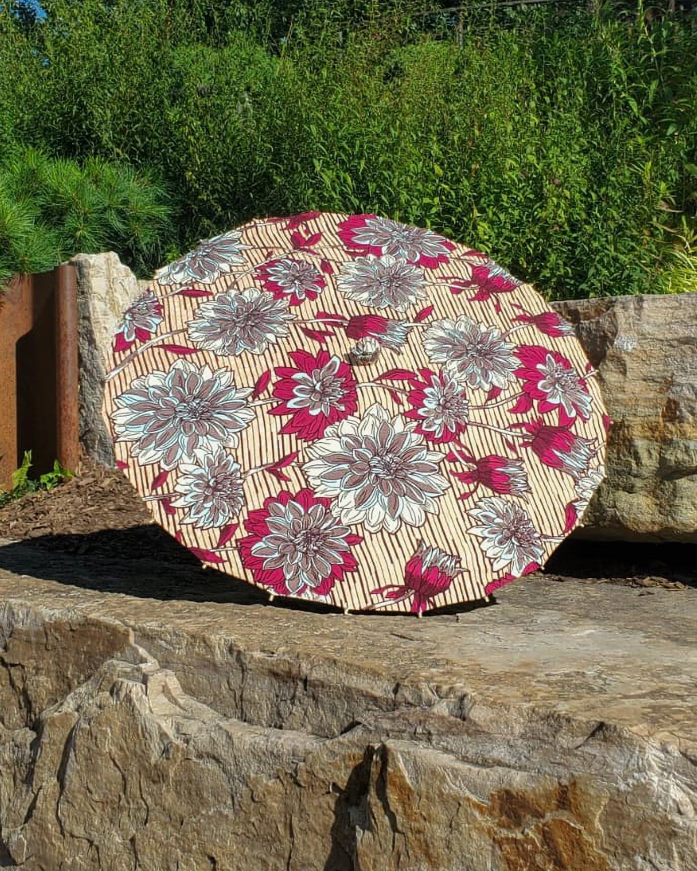 strawberry opal handmade parasol exterior, medium size, with afro-inspired design on a stone slab