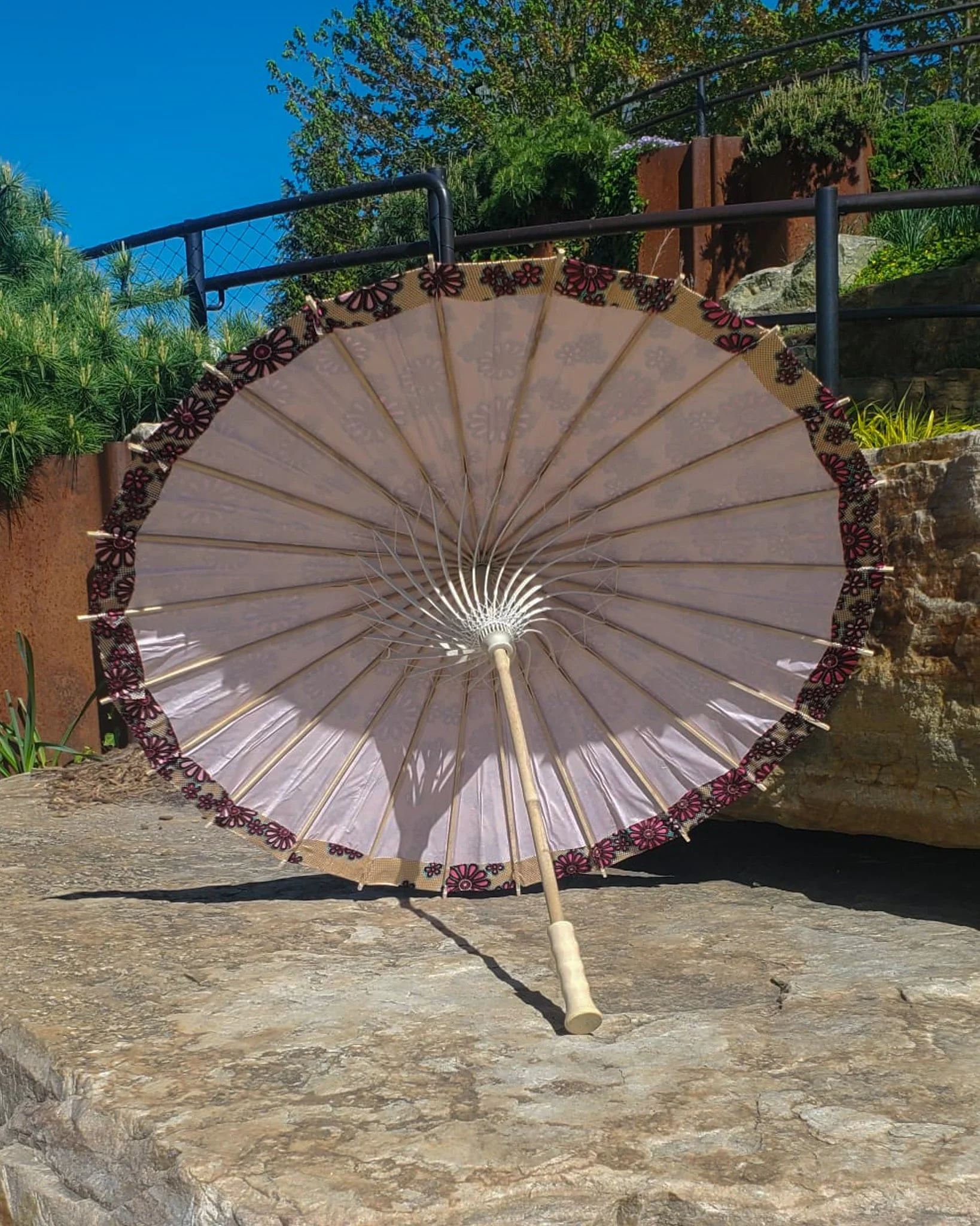 rhodochrosite handmade parasol interior, medium size, with afro-inspired design on a stone slab
