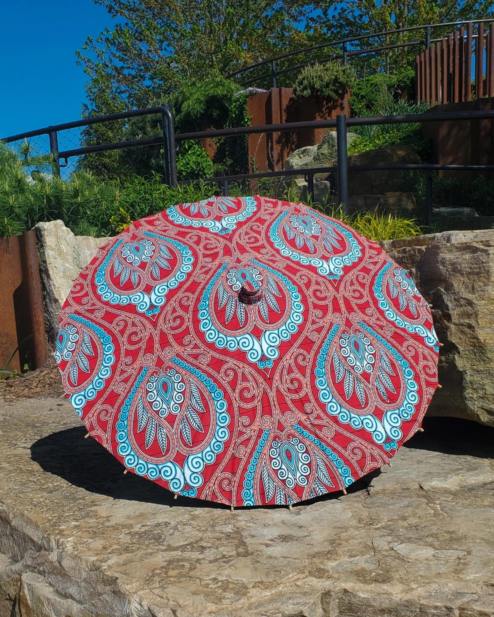 sonora sunrise handmade parasol exterior, medium size, with afro-inspired design on a stone slab