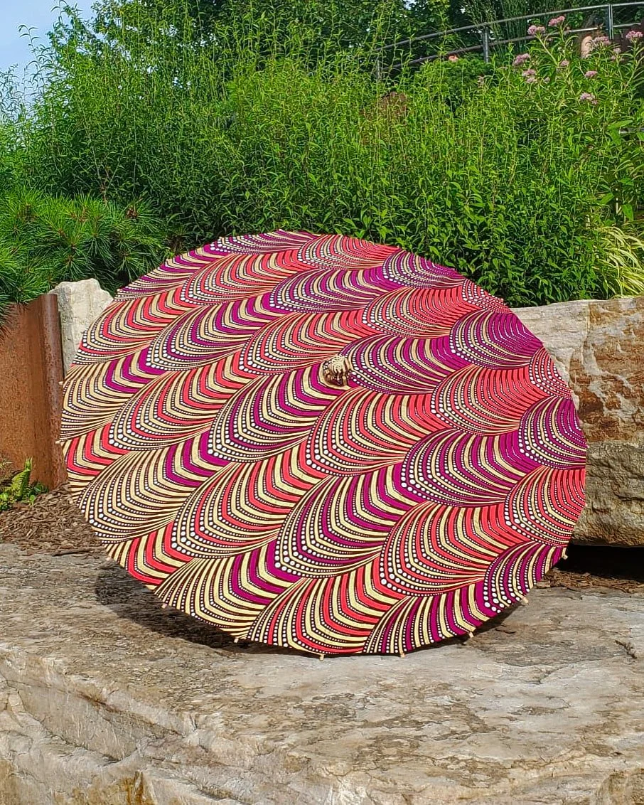 erythrite handmade parasol exterior, medium size, with afro-inspired design on a stone slab