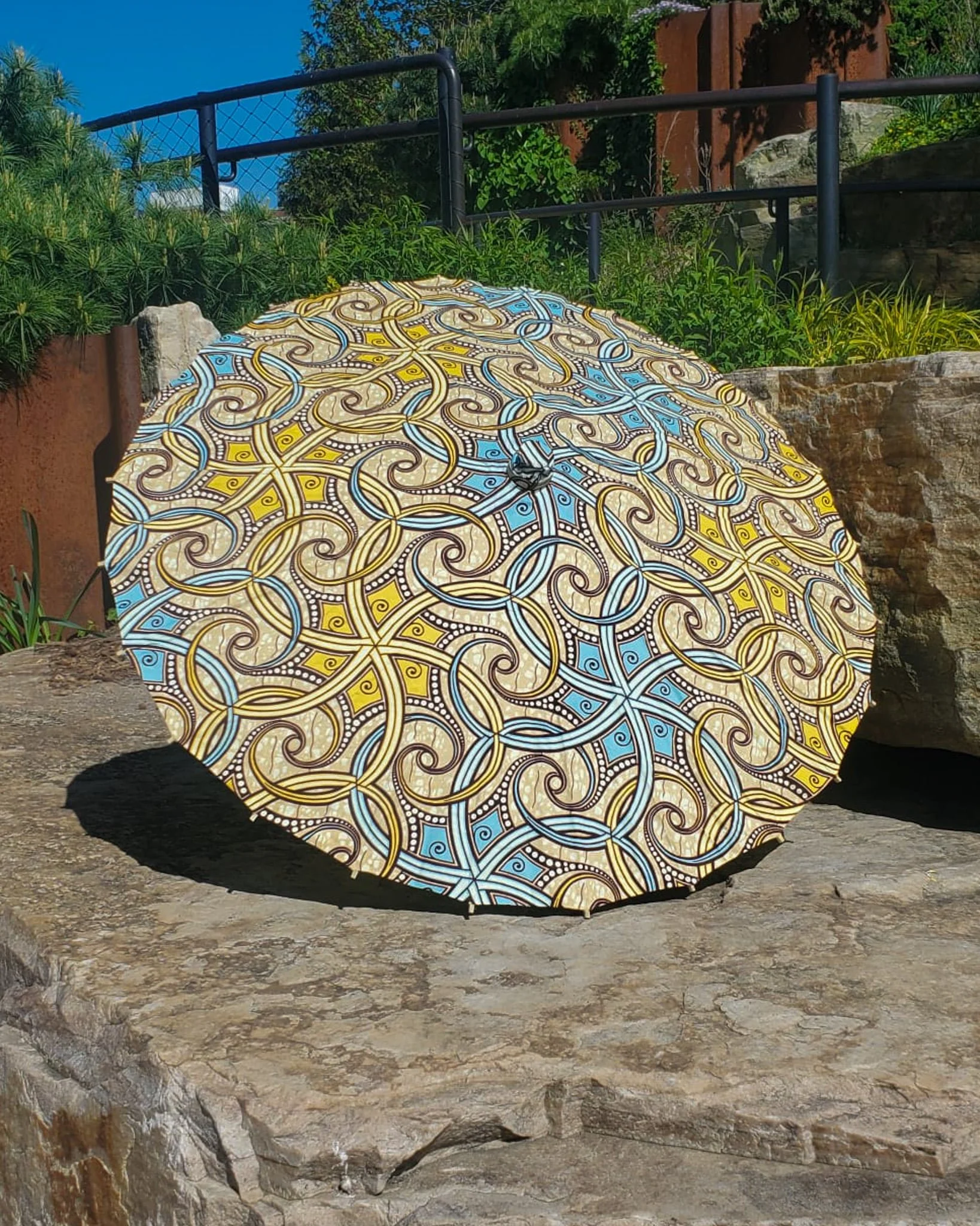 euclase handmade parasol exterior, medium size, with afro-inspired design on a stone slab