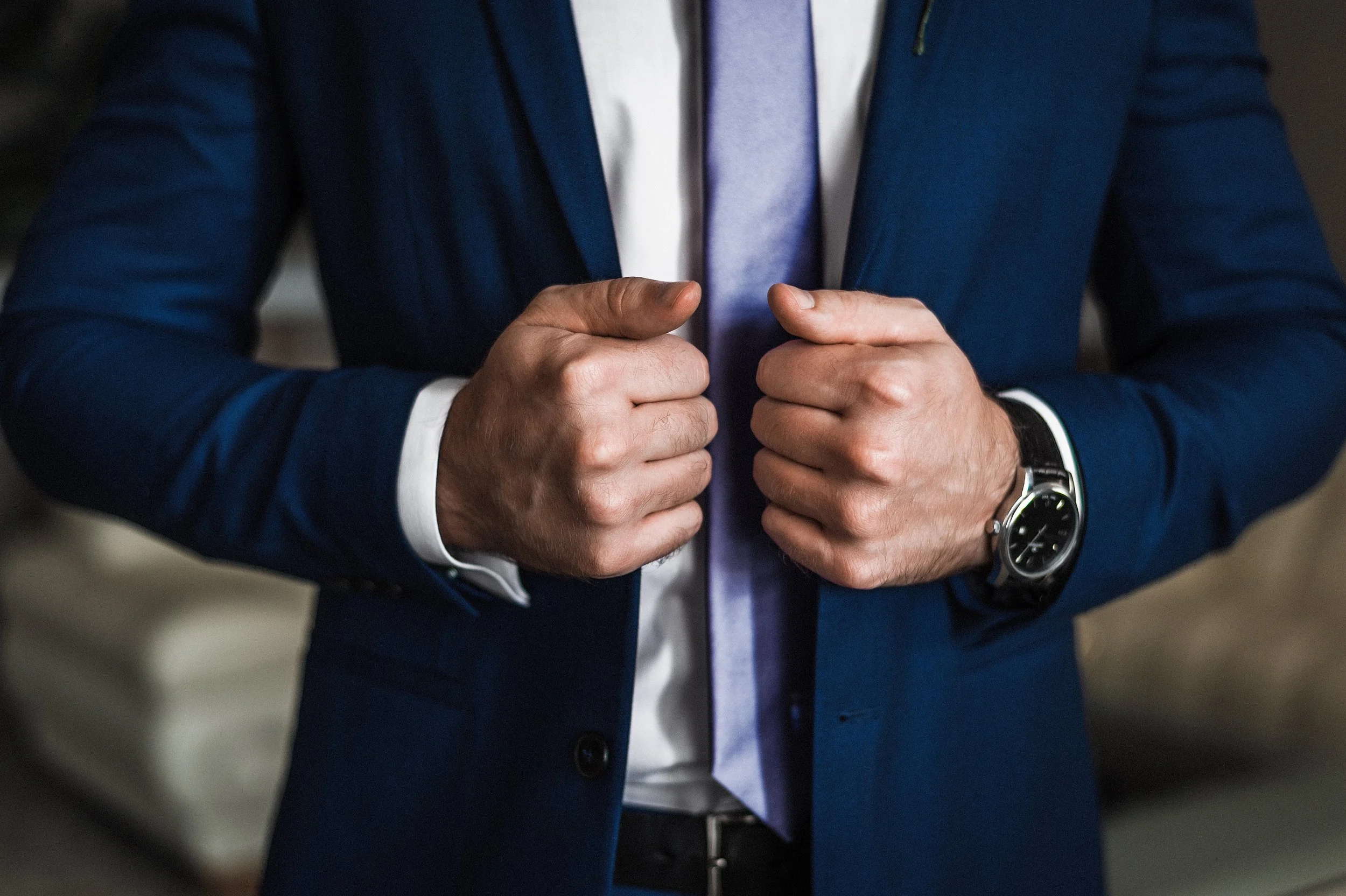 man holding lapels of suit jackets as if to say he's ready for action