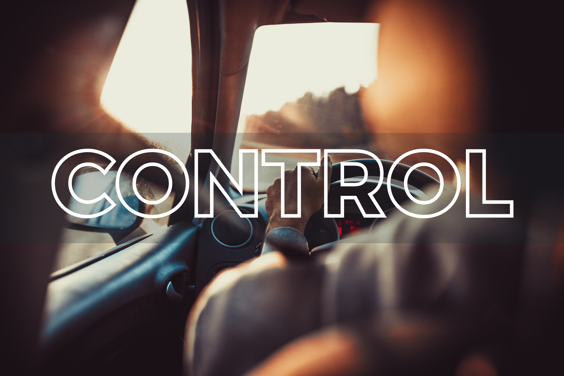 A person driving a car during sunset, with their hand on the steering wheel, viewed from the backseat, overlaid with a large white letter C.