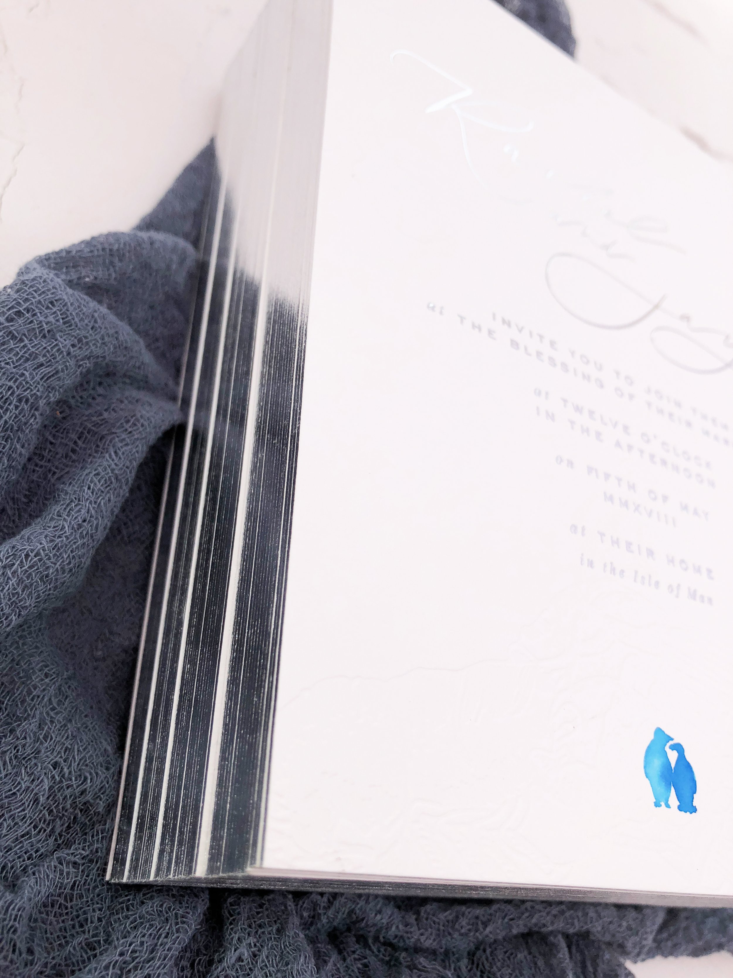 Silver gilt edged invitations, each one featuring a hand painted pair of penguins