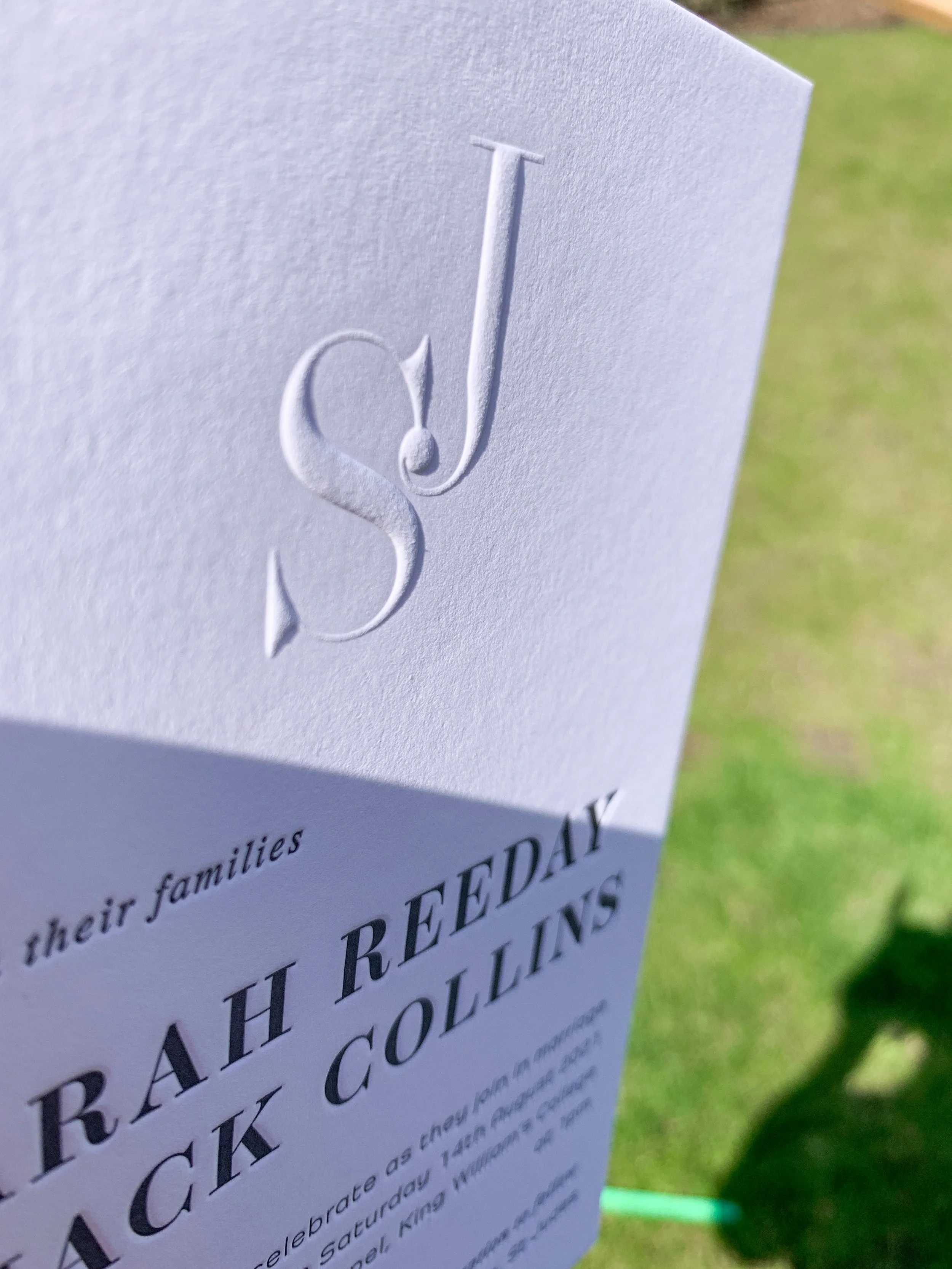 Letterpress invitation with a blind (no ink) embossed wedding logo 