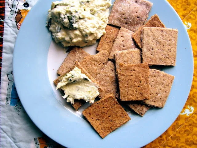 Rae goes into the kitchen and emerges with something other than an empty oreo box
