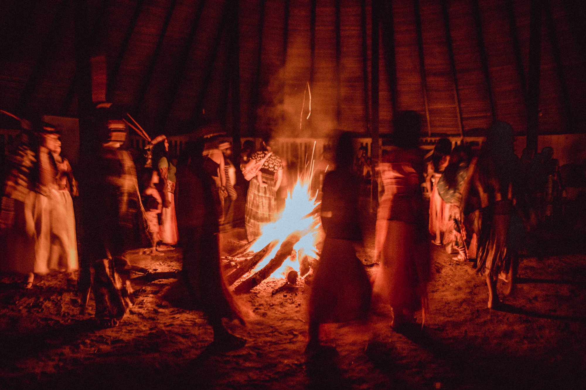 Fire with people dancing around it in the forest