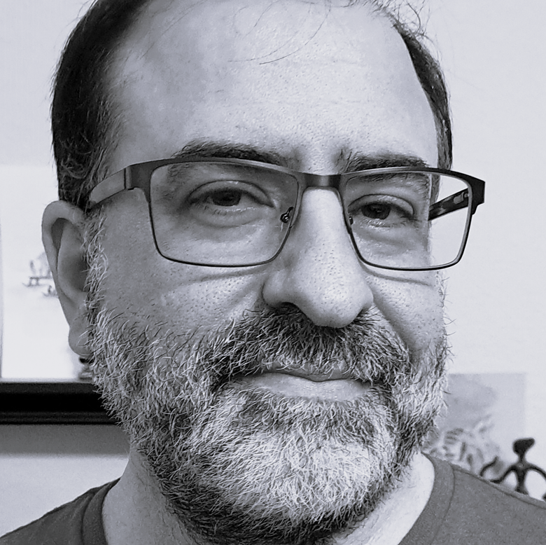 A black-and-white, temple-to-beard headshot of Graham Robert Scott in T-shirt and glasses.