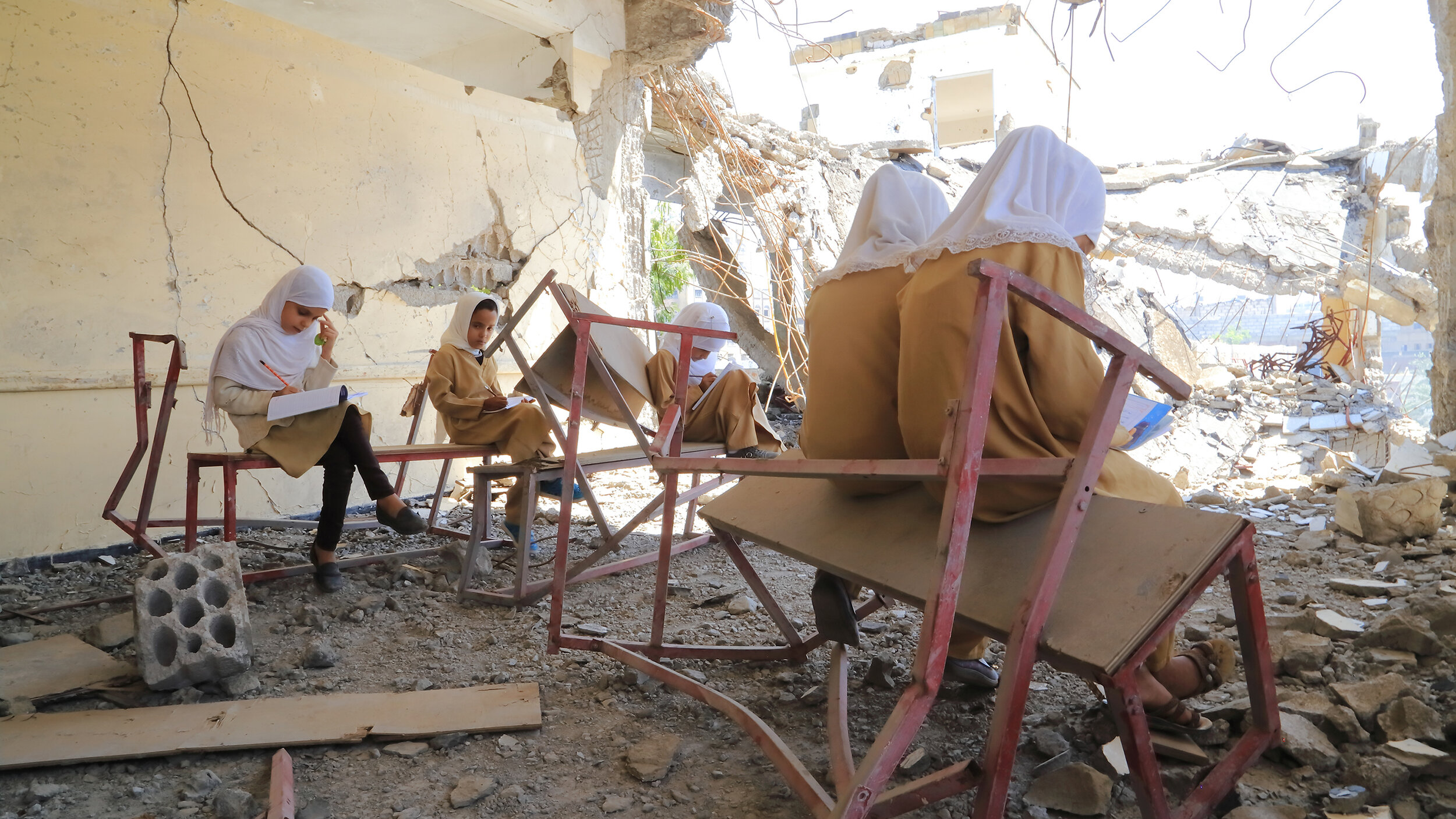 Girls study in a classroom destroyed by airstrikes in Taizz, Yemen. © 2019 UNICEF/UN1275387/Al-Sabri