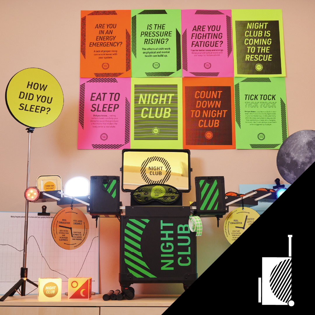 A display about sleep and night clubs featuring colorful posters with questions and facts, a moon-shaped lamp, and various devices and signs related to sleep, energy, and nighttime activities.