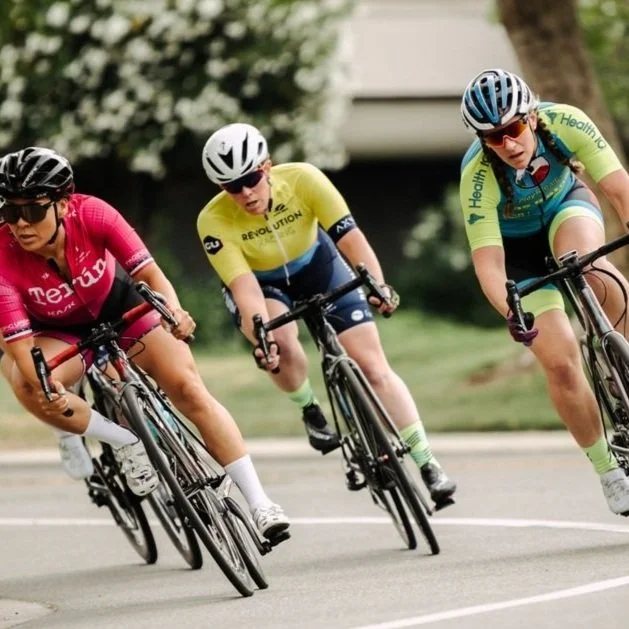 Three women on bicycles racing on a track