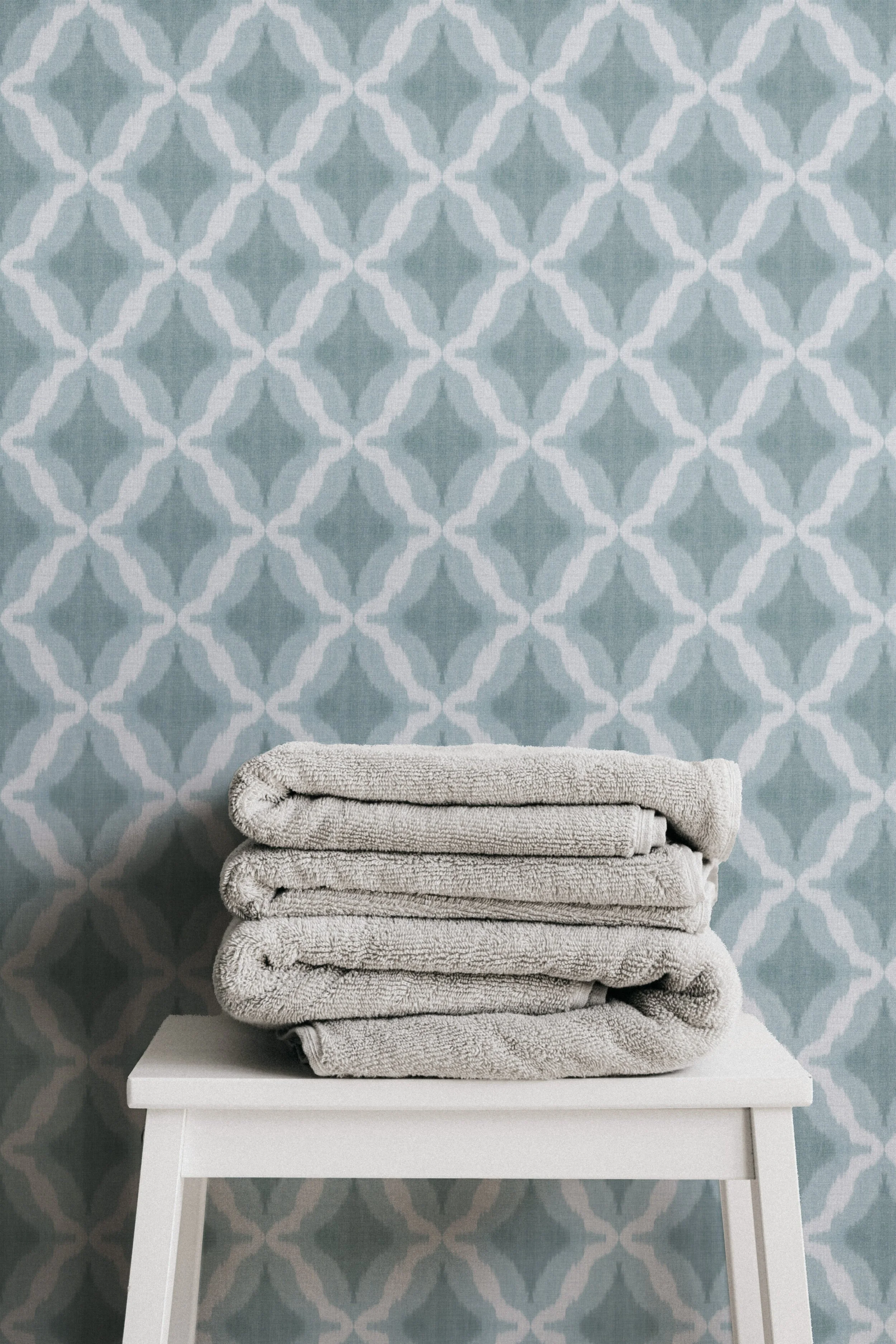 Original blue geometric wallpaper with a hand painted watercolor ikat pattern displayed in a modern bathroom.