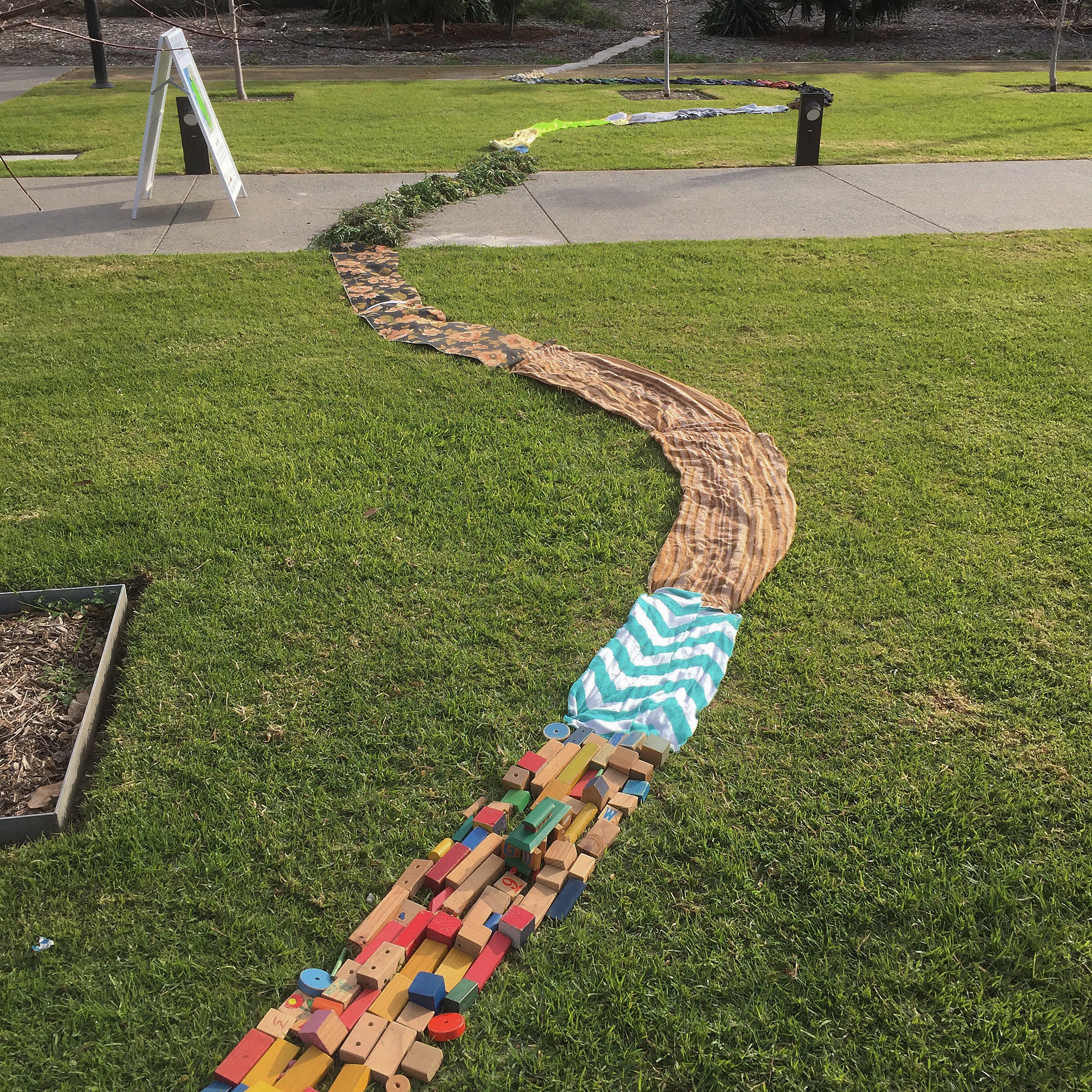   House Estuary  2018. Wheatgrass, sunflowers, clothes, sand, chalk, charcoal, wood, wire, bricks, stone, found materials. 