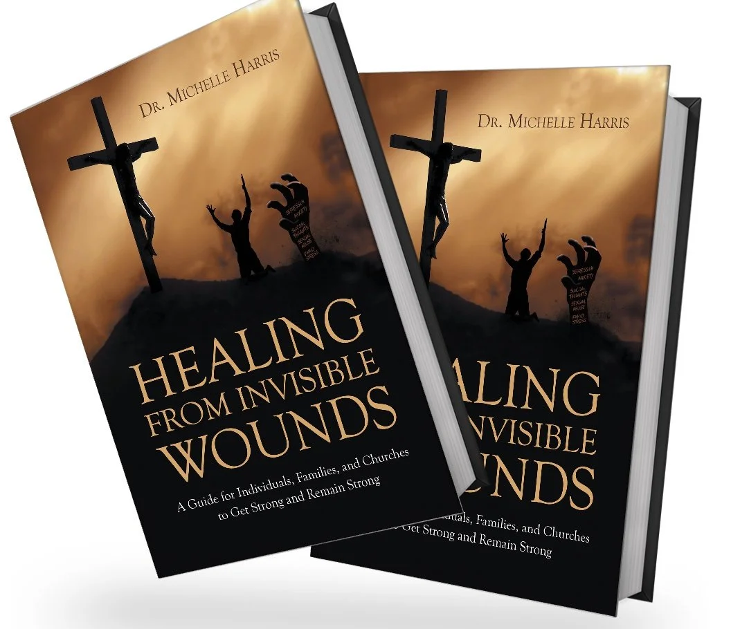 Two books titled 'Healing from Invisible Wounds' by Dr. Michelle Harris are displayed, featuring a cover with a silhouette of a crucifixion scene and a person with raised hands, set against a sunset sky.
