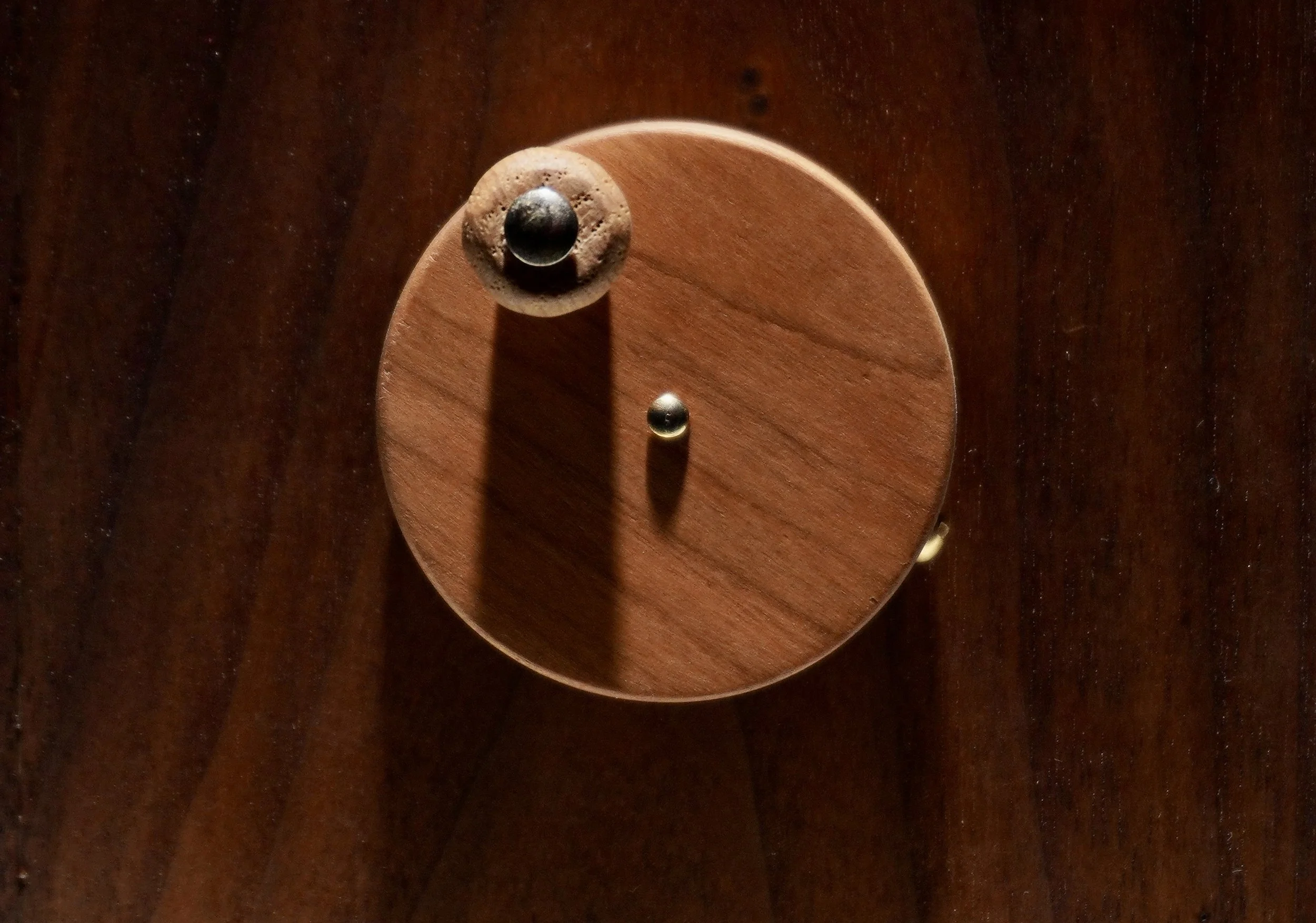 Close-up of a wooden spinning top toy on a dark wooden surface.