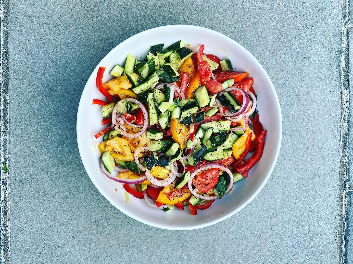 Tomatoes in bowls, you say @unsqgreenmarket? 4 Heirlooms, 1/2 of a large red onion, 8 smashed Kirby cucumbers, and 1 red bell pepper tossed with @californiaoliveranch olive oil, lemon, salt, and pepper