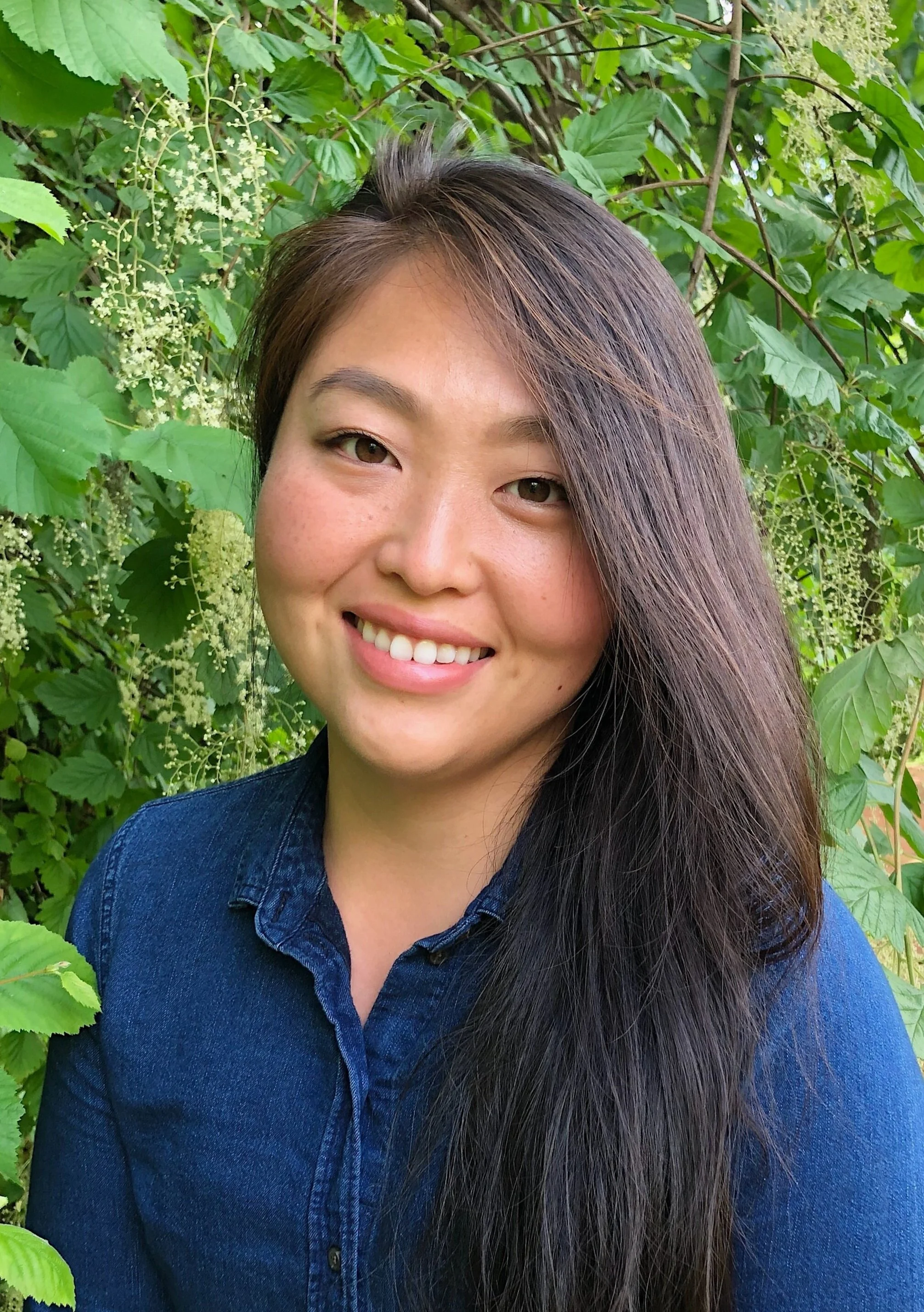 Photo of Dr. Tak smiling with plants behind