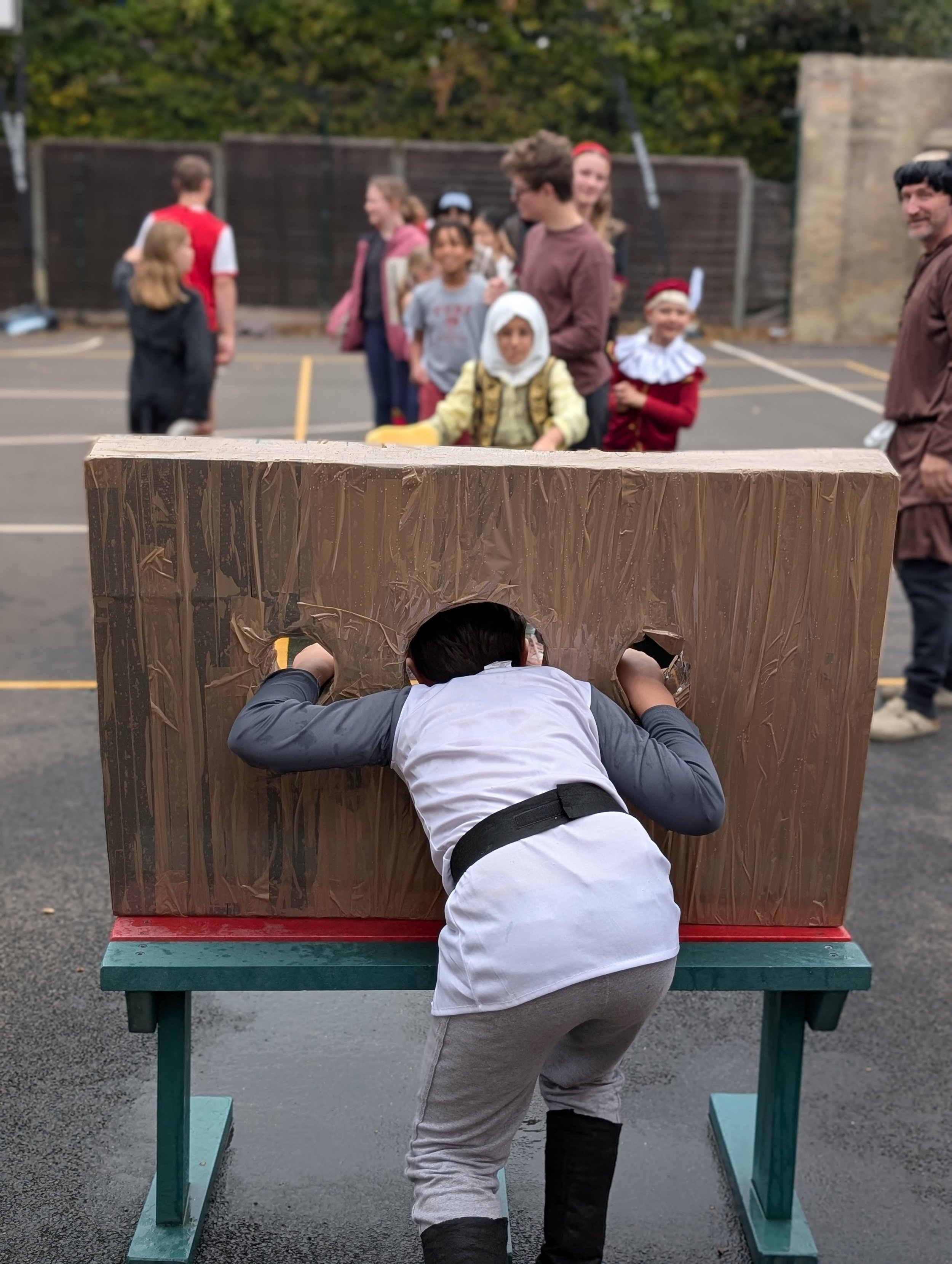 Students enjoying the stocks at the Tudor fair.