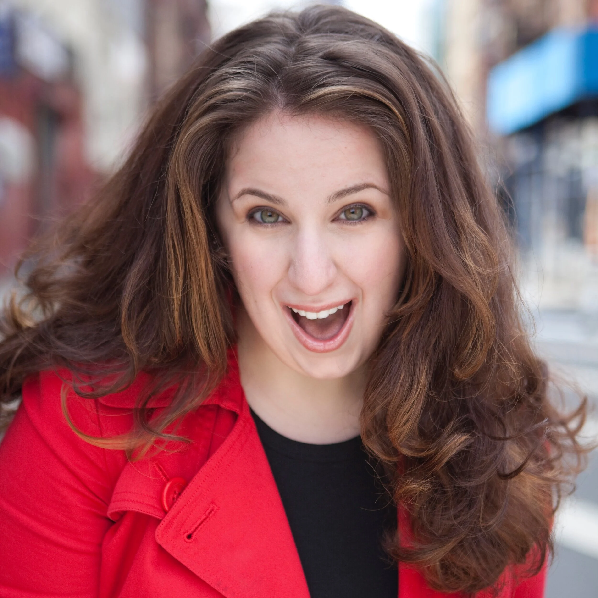 Singer, actor, and voice coach, Marisa del Campo, wearing a red coat.