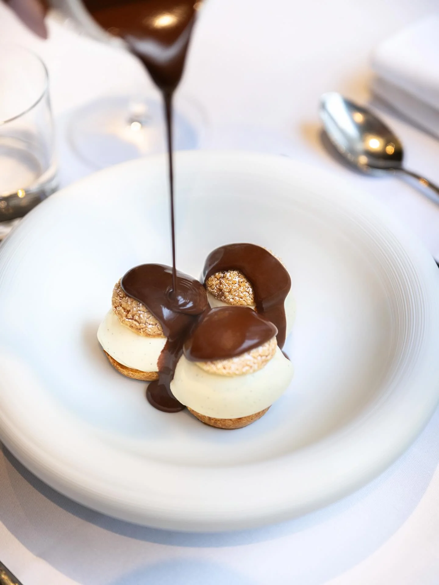 Notre profiterole. Une p&acirc;te &agrave; choux l&eacute;g&egrave;re, glace vanille onctueuse et chocolat chaud maison. Intemporel.