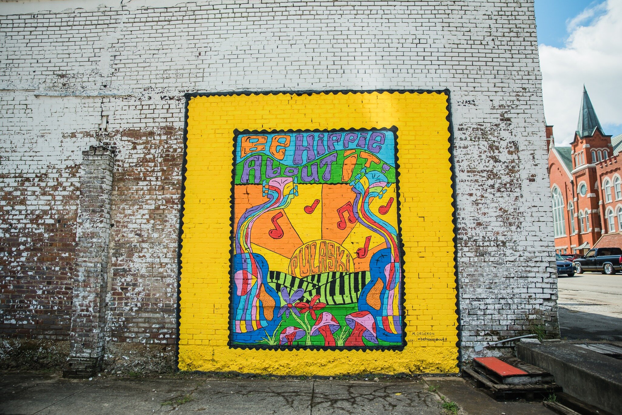 This week, we're highlighting the murals that serve as art and photo op in Historic Downtown Pulaski 📸 🖼️

Located at 218 N 2nd St on the Eslick Tractor &amp; Motor Co. building, the &quot;Be Hippie About It&quot; mural is painted in a 70s style de