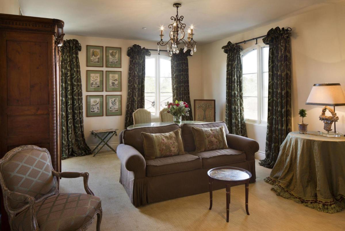 Sitting room of grand suite with dining table, sofa and fireplace.