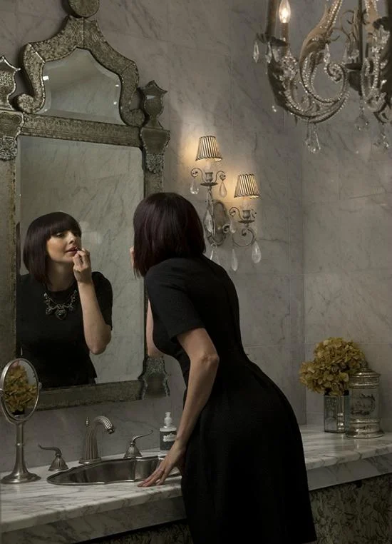 woman putting on makeup in a mirror