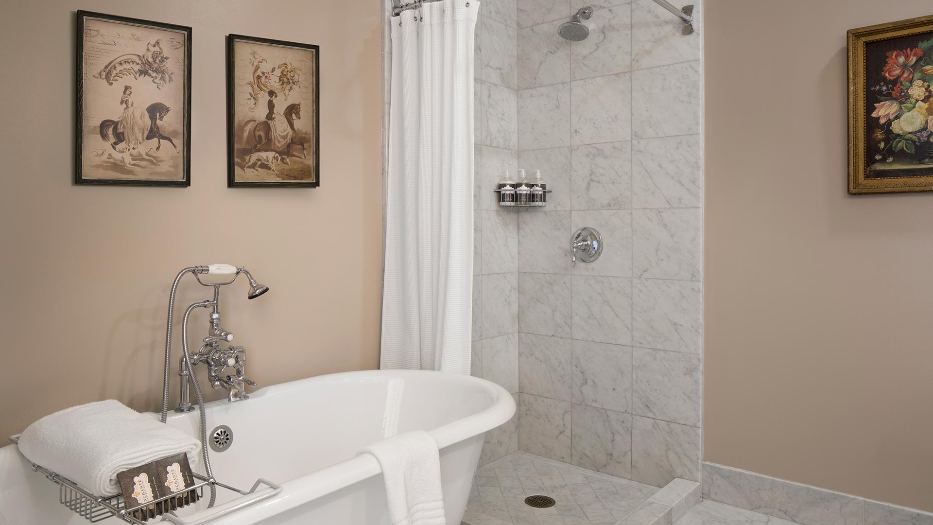 Carrera marble bathroom with porcelain pedestal tub.