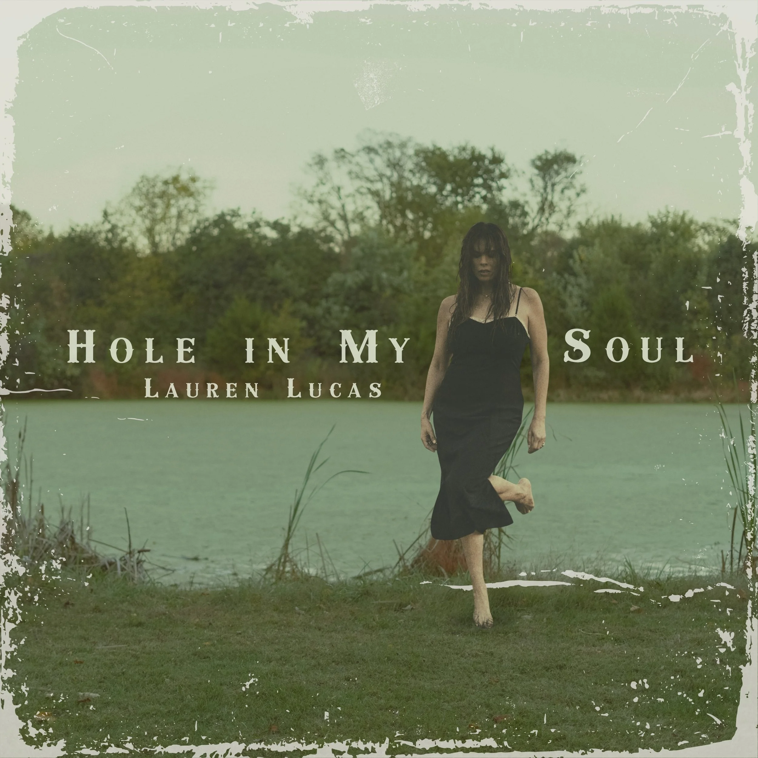 Album artwork for Hole in My Soul by Lauren Lucas. Woman with brown wet hair walking in blue dress from swampy pond