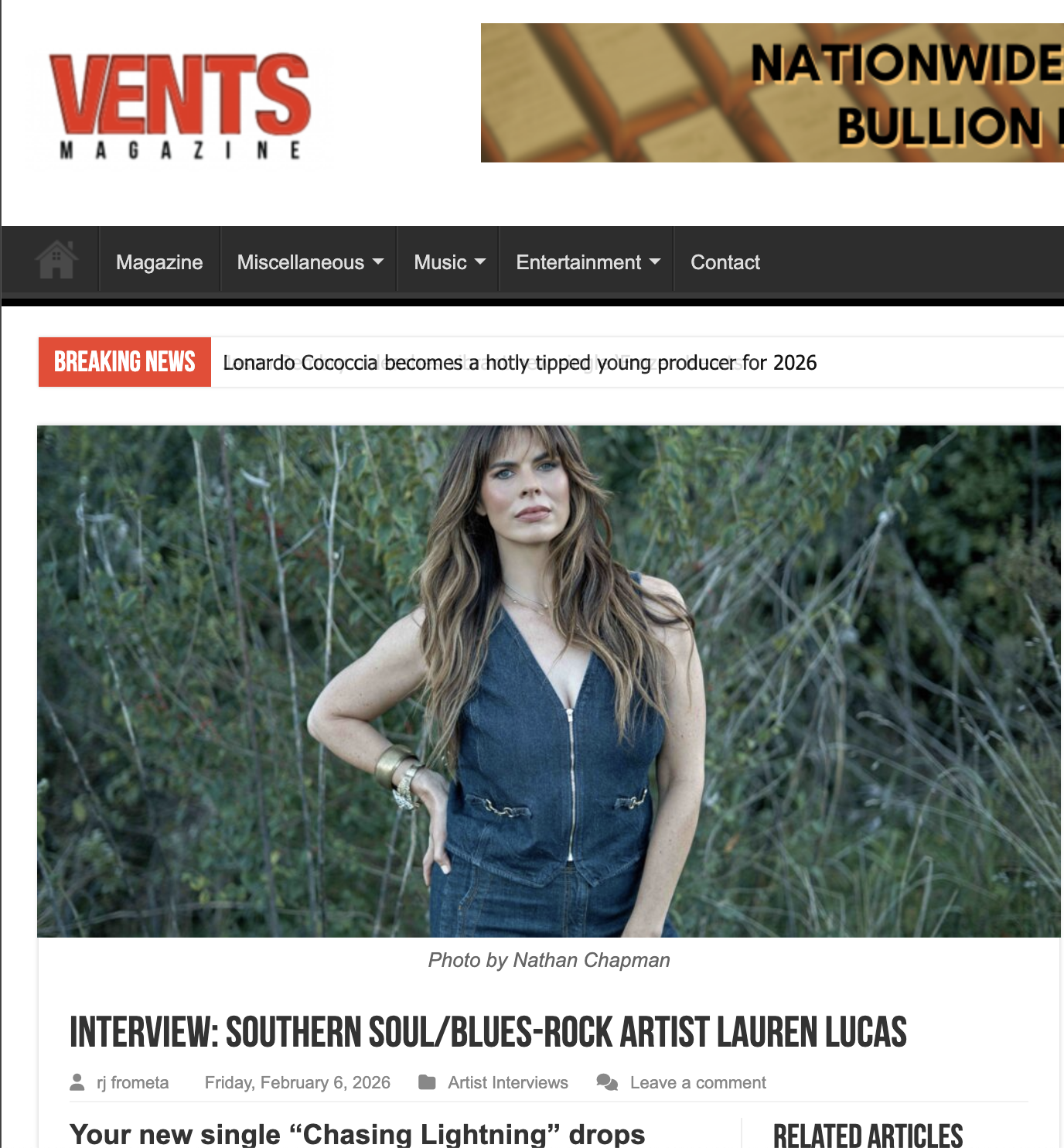 Woman with long dark hair standing in nature with hand on hip in denim outfit