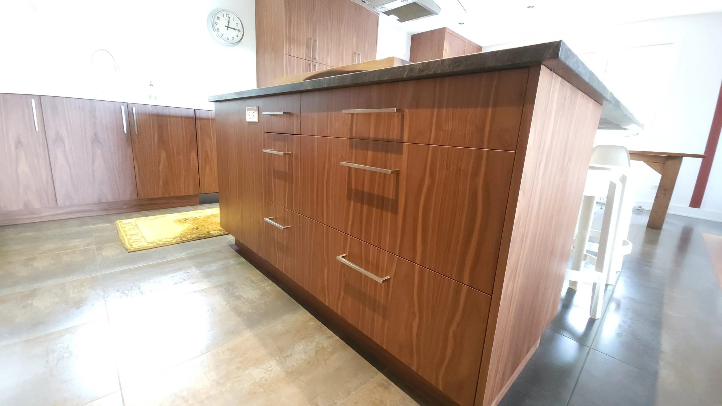 Wood grain cabinet fronts and drawers, finished with simple metal pulls.