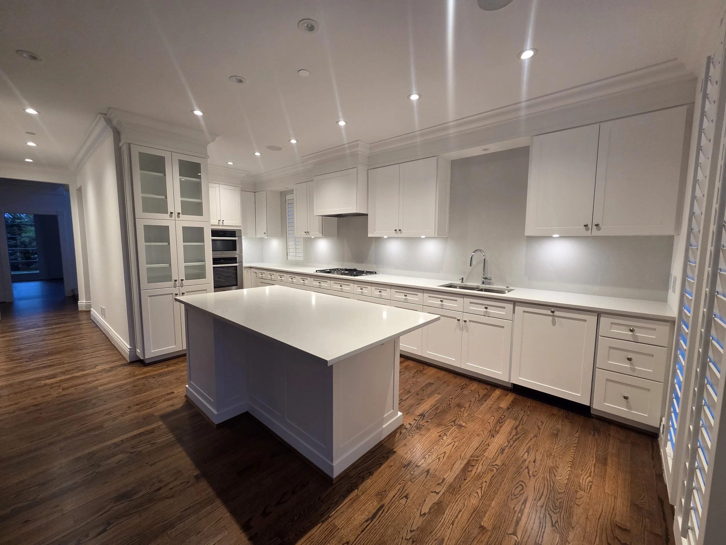 White shaker kitchen cabinetry with detailed trim and integrated storage.
