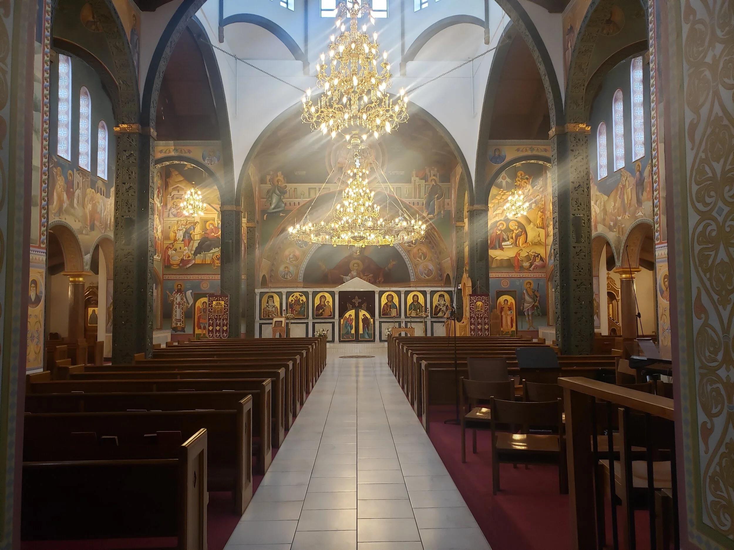 Interior of a Greek Orthodox church featuring Byzantine iconography on the ceiling