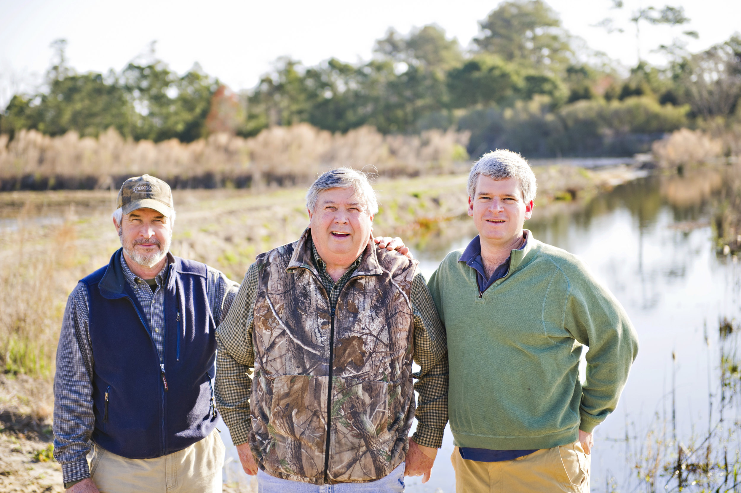 Tommy, Jerry, and John Wright stand on the farm at Outer Banks Vineyard and Winery, Sanctuary Vineyards. 