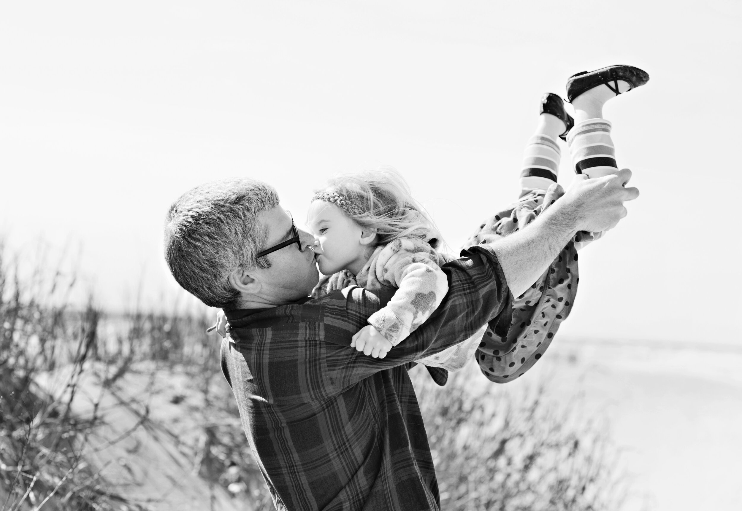 John Wright holding his daughter, Poppy Wright in the air in Currituck, NC. 