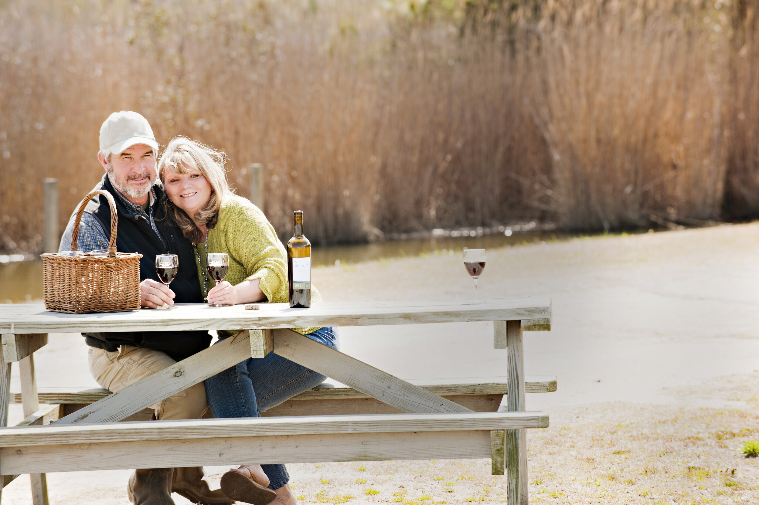 Tommy and Candy Wright sitting at a picnic table at the creek at the back of Deep Creek Farm. 