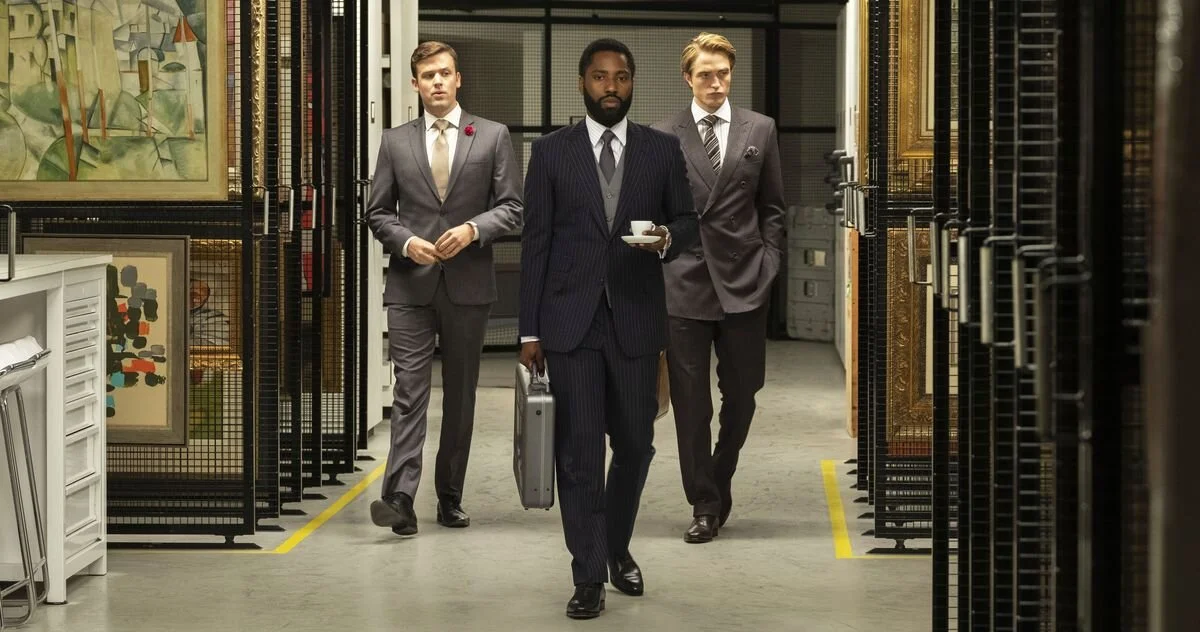 John David Washington’s “Protagonist”, along with Robert Pattinson (also good in this movie) looking suave and well-dressed as they stroll into a building prepping for an art heist.