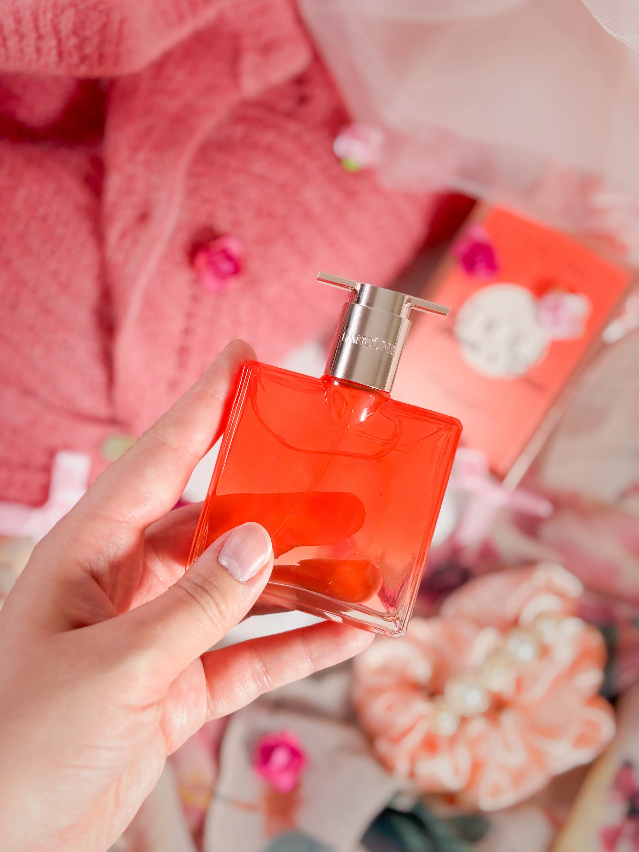 Zoom sur le flacon du parfum Lancôme Idôle Peach N Roses, un flacon plat au dégradé pêche orangé