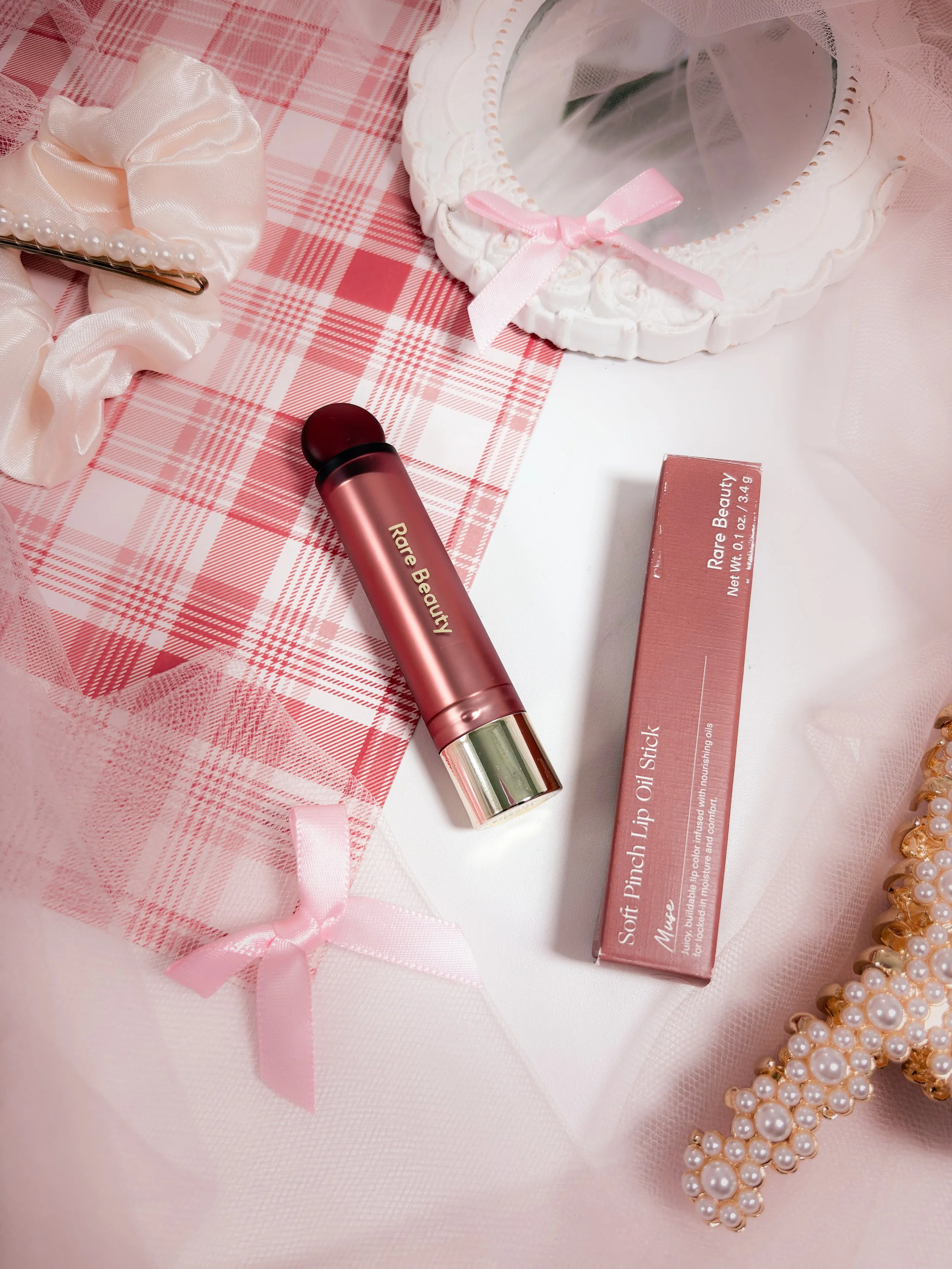 Zoom sur le packaging de l'huile à lèvres Soft Pinch Lip Oil Stick de Rare Beauty en teinte Muse