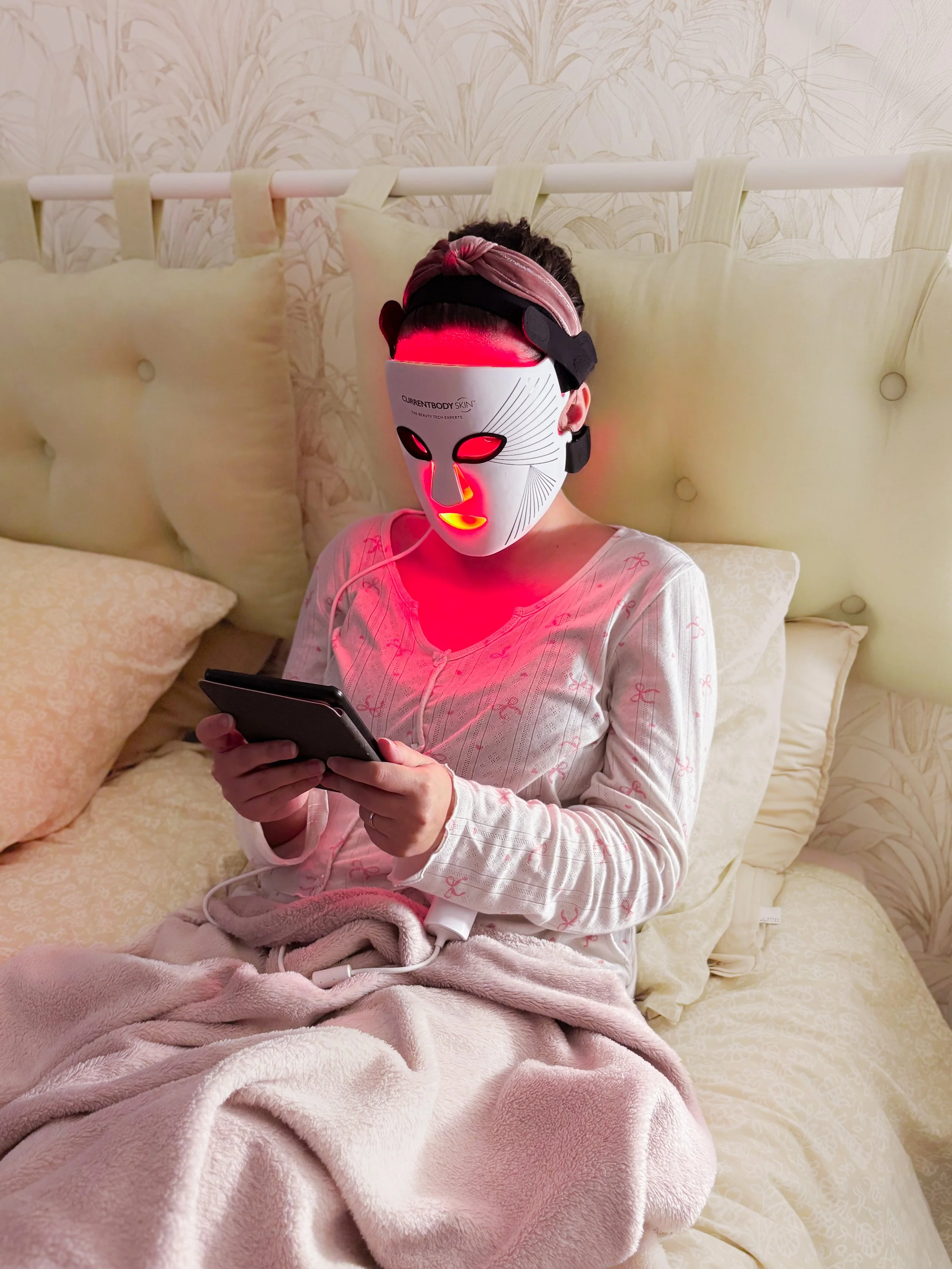 Séance de luminothérapie avec le Masque LED Série 2 CurrentBody pendant la lecture d’un roman