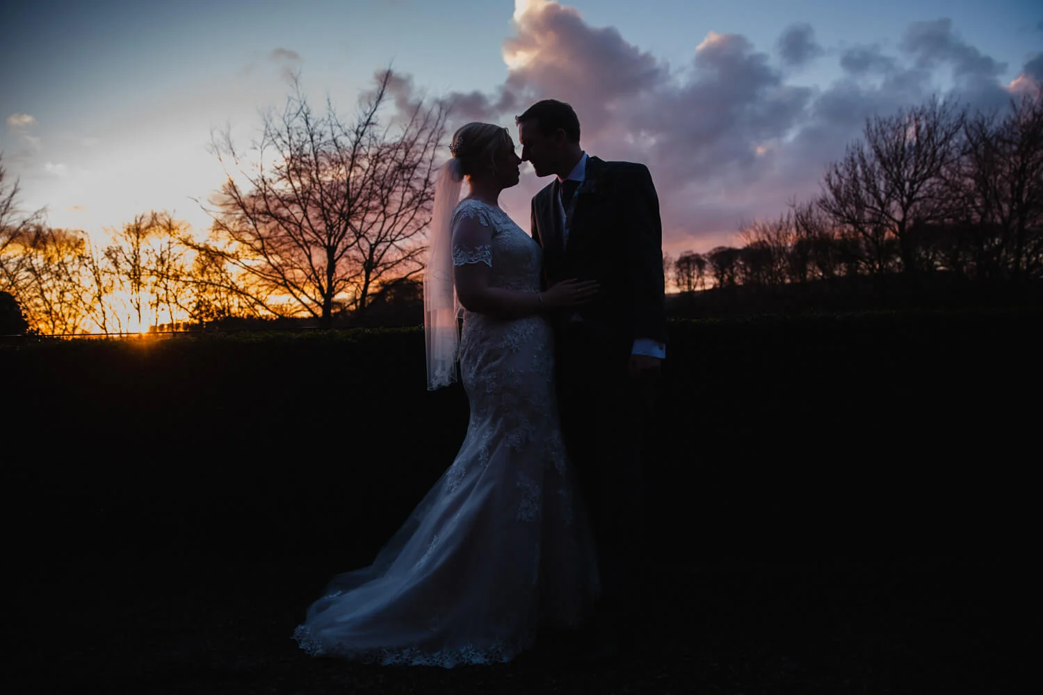 Rachel and David silhouetted against the spring sunset at Mitton Hall