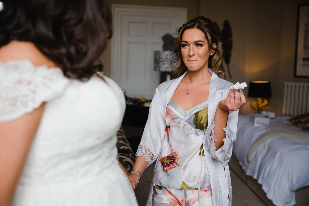 bridesmaid in tears holding tissues before ceremony