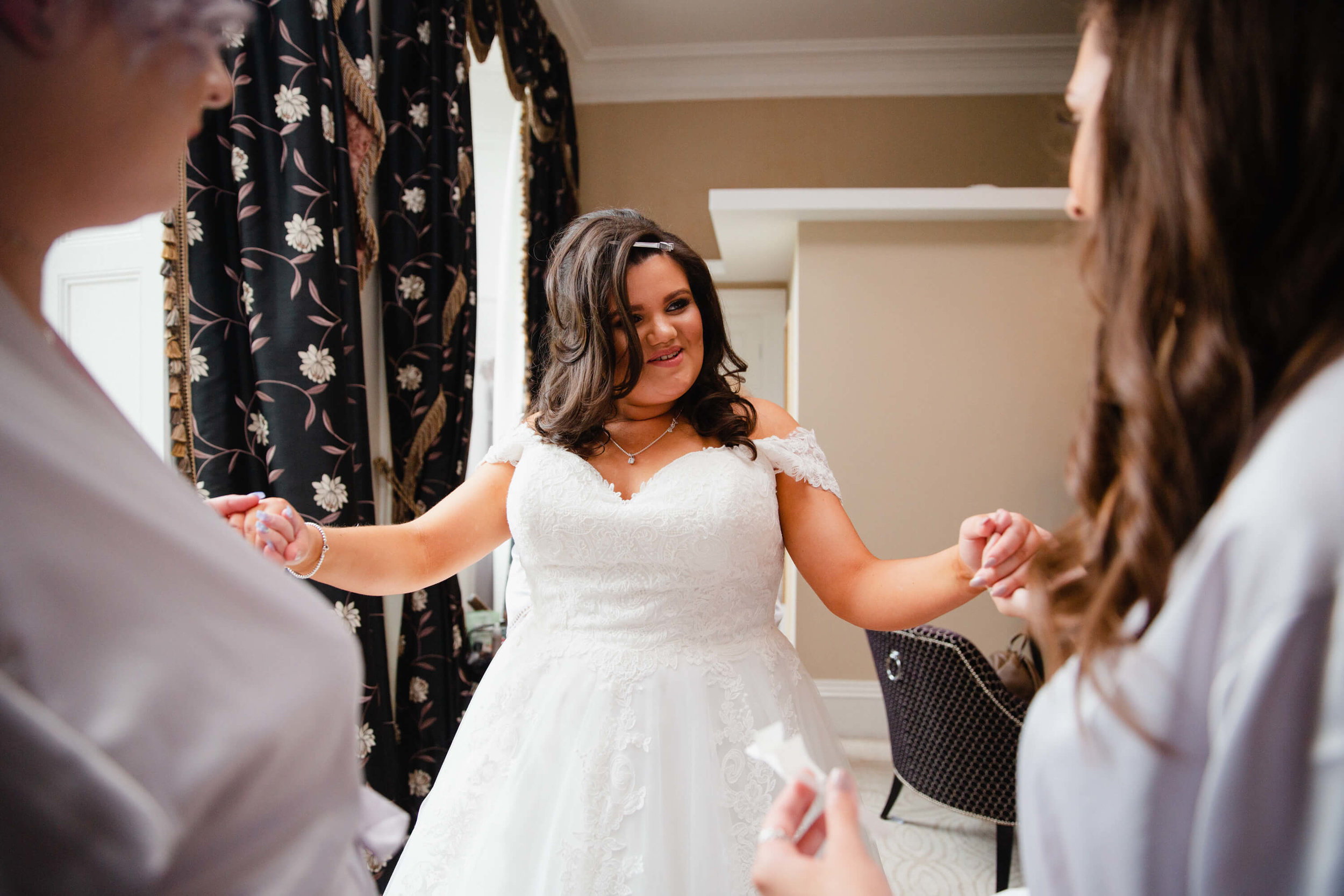 bride holding hands with bridesmaids